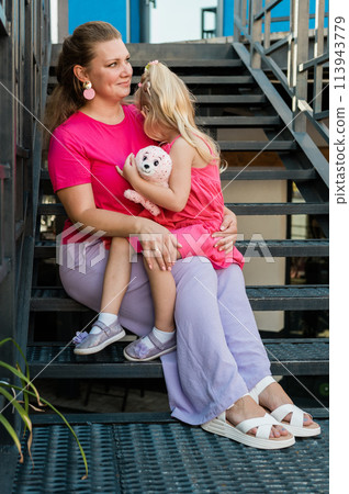 Mother holds and have fun her child with hearing aids and cochlear implants summer outdoor . Deaf and health concept. Diversity and Inclusion and people with disability concept. Copy space 113943779