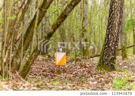 Orienteering. Control point Prism and electric composter for orienteering in the spring forest. Orienteering. Control point Prism and electric composter for orienteering in the spring forest. 113943879