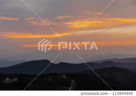 Majestic mountain range silhouetted by sunset 113944448
