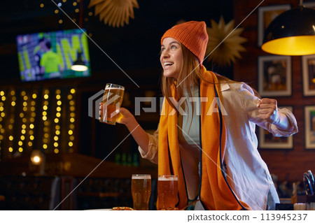 Shouting woman football fan watching TV match in sports bar Shouting woman football fan watching TV match in sports bar 113945237