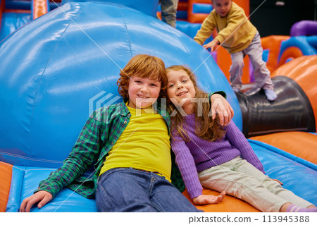 Cute little kids of different age playing on inflatable bounce house 113945388