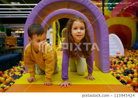Little brother and sister positive children playing in indoor park 113945424