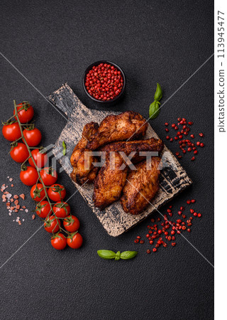 Delicious juicy chicken wings baked on the grill with salt, spices and herbs 113945477