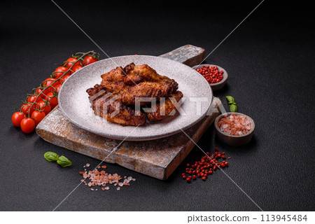 Delicious juicy chicken wings baked on the grill with salt, spices and herbs 113945484