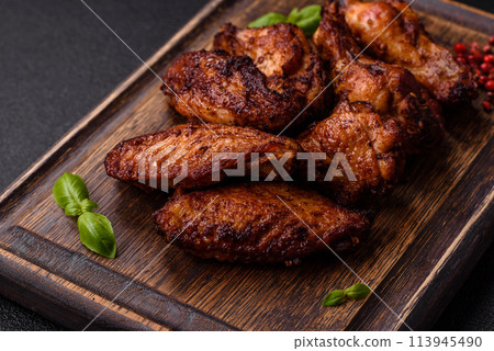 Delicious juicy chicken wings baked on the grill with salt, spices and herbs 113945490