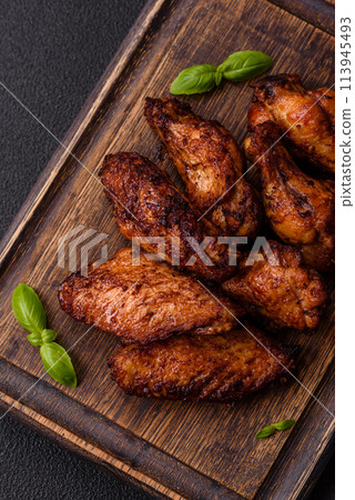 Delicious juicy chicken wings baked on the grill with salt, spices and herbs 113945493