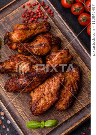 Delicious juicy chicken wings baked on the grill with salt, spices and herbs 113945497