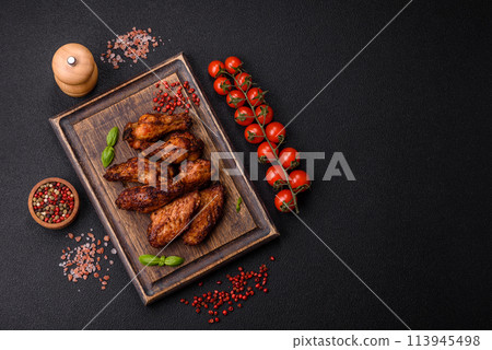 Delicious juicy chicken wings baked on the grill with salt, spices and herbs 113945498
