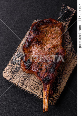 Delicious juicy beef steak on the bone, tomahawk with salt, spices and herbs 113945507