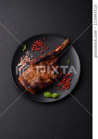 Delicious juicy beef steak on the bone, tomahawk with salt, spices and herbs 113945515