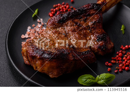 Delicious juicy beef steak on the bone, tomahawk with salt, spices and herbs 113945516