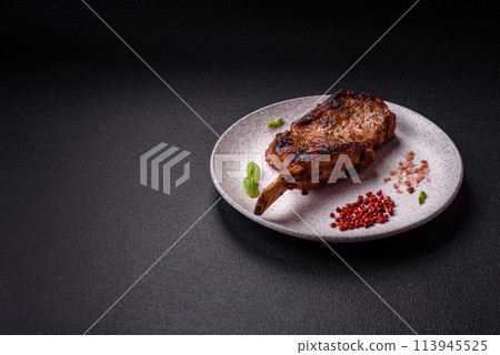 Delicious juicy beef steak on the bone, tomahawk with salt, spices and herbs 113945525