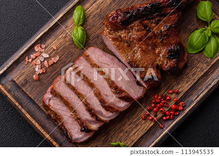 Delicious juicy beef steak on the bone, tomahawk with salt, spices and herbs Delicious juicy beef steak on the bone, tomahawk with salt, spices and herbs 113945535