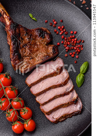 Delicious juicy beef steak on the bone, tomahawk with salt, spices and herbs 113945547