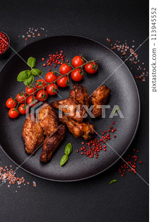 Delicious juicy chicken wings baked on the grill with salt, spices and herbs Delicious juicy chicken wings baked on the grill with salt, spices and herbs 113945552