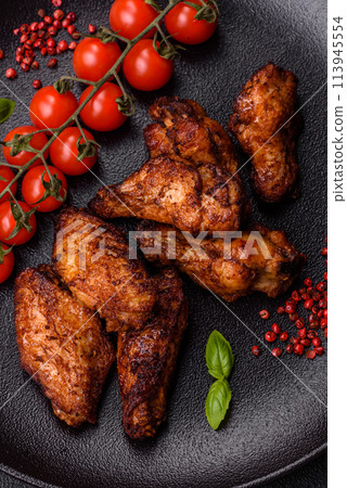 Delicious juicy chicken wings baked on the grill with salt, spices and herbs 113945554