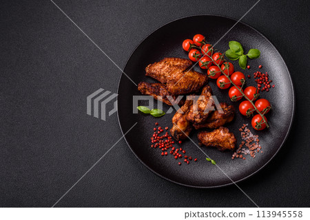 Delicious juicy chicken wings baked on the grill with salt, spices and herbs Delicious juicy chicken wings baked on the grill with salt, spices and herbs 113945558
