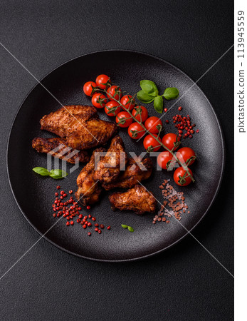 Delicious juicy chicken wings baked on the grill with salt, spices and herbs 113945559