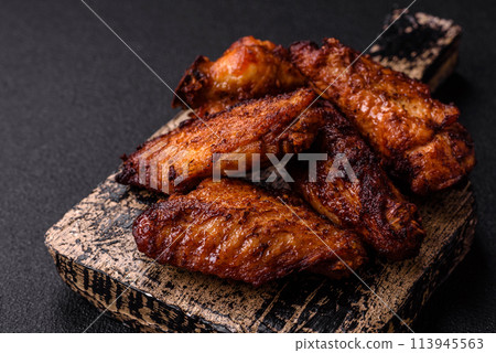 Delicious juicy chicken wings baked on the grill with salt, spices and herbs 113945563