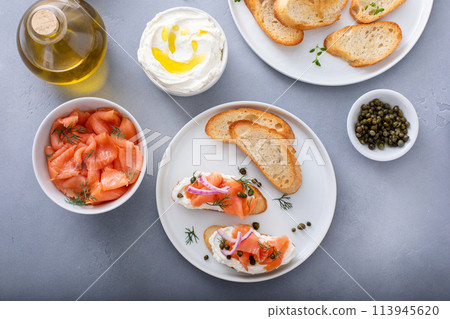 Salmon and cream cheese bruschetta with dill and capers 113945620