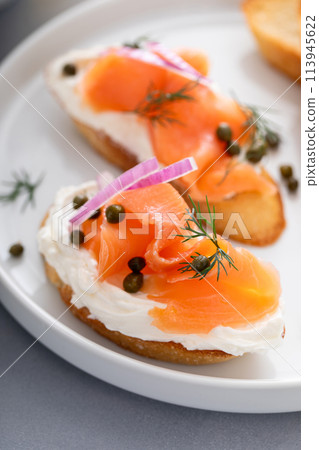 Salmon and cream cheese bruschetta with dill and capers 113945622