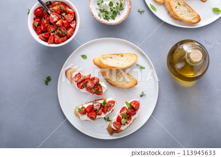 Tomato basil and cream cheese bruschettas with fresh cherry tomatoes 113945633