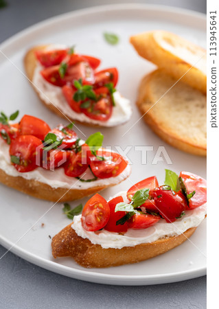 Tomato basil and cream cheese bruschettas with fresh cherry tomatoes 113945641