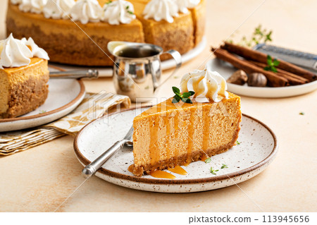 Pumpkin cheesecake with fall spices topped with whipped cream Pumpkin cheesecake with fall spices topped with whipped cream 113945656