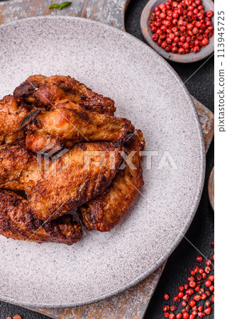 Delicious juicy chicken wings baked on the grill with salt, spices and herbs 113945725