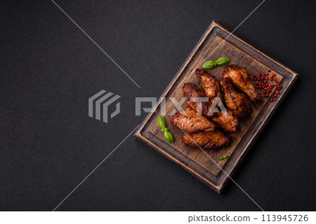 Delicious juicy chicken wings baked on the grill with salt, spices and herbs Delicious juicy chicken wings baked on the grill with salt, spices and herbs 113945726
