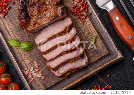 Delicious juicy beef steak on the bone, tomahawk with salt, spices and herbs Delicious juicy beef steak on the bone, tomahawk with salt, spices and herbs 113945734