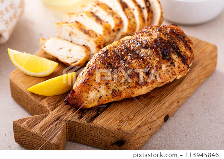 Grilled chicken with spice rub and lemon on a cutting board 113945846