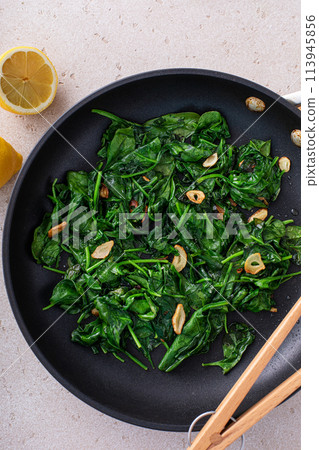 Sauteed spinach with garlic in a skillet 113945856