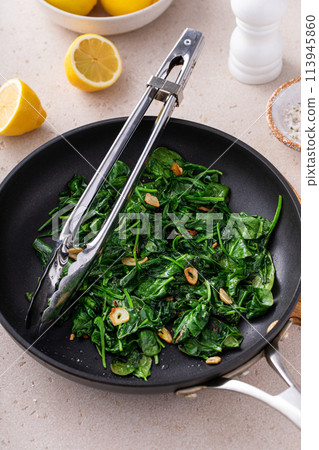 Sauteed spinach with garlic in a skillet 113945860