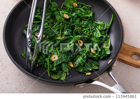 Sauteed spinach with garlic in a skillet 113945861