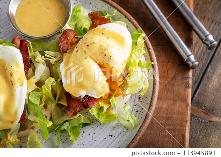 Eggs Benedict with bacon and lettuce on english muffins Eggs Benedict with bacon and lettuce on english muffins 113945891