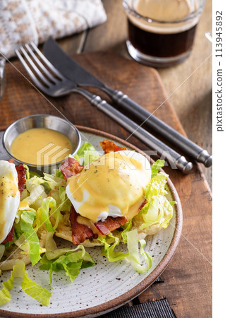 Eggs Benedict with bacon and lettuce on english muffins 113945892