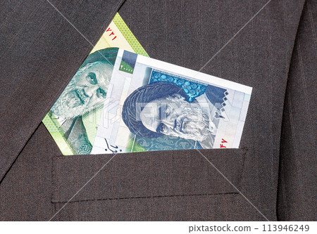Banknotes of Iranian currency sticking out of the businessman suit pocket Banknotes of Iranian currency sticking out of the businessman suit pocket 113946249