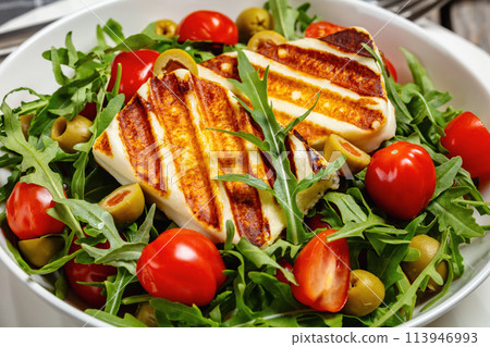 salad with grilled halloumi greek cheese in bowl 113946993