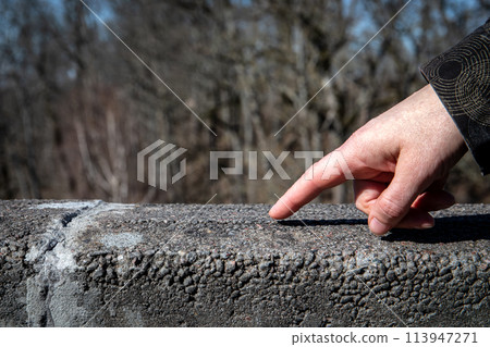 Hand on a stone railing, stone pillars as a support Hand on a stone railing, stone pillars as a support 113947271