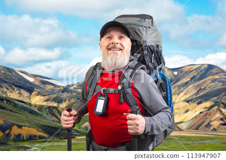 happy bearded man traveler with hiking equipment against the backdrop of a mountain happy bearded man traveler with hiking equipment against the backdrop of a mountain 113947907