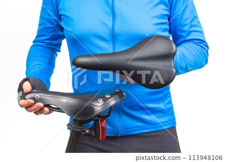 cyclist inspects, compares and selects a saddle for a bicycle. cyclist inspects, compares and selects a saddle for a bicycle. 113948106