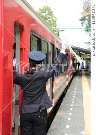 A conductor on the Hakone Tozan Railway giving the signal to depart (Ashigarashimo District, Kanagawa Prefecture, Japan) 113948375