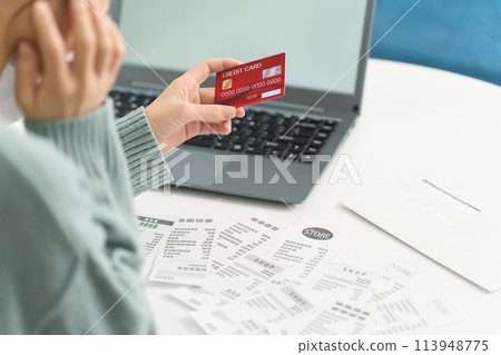 A woman worried about overspending on her credit card 113948775