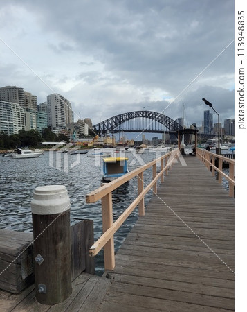Sydney's harbour foreshore set against the famous Sydney Harbour bridge on a cloudy overcast day Sydney's harbour foreshore set against the famous Sydney Harbour bridge on a cloudy overcast day 113948835