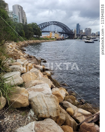 Sydney's harbour foreshore set against the famous Sydney Harbour bridge on a cloudy overcast day 113948838