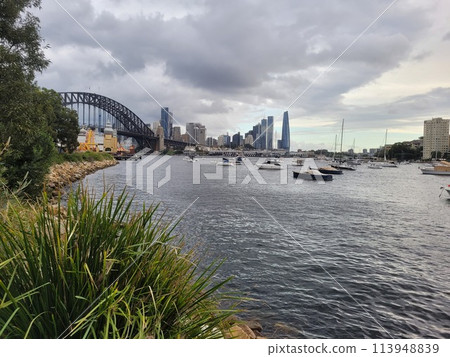 Sydney's harbour foreshore set against the famous Sydney Harbour bridge on a cloudy overcast day 113948839