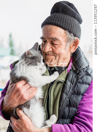 Old Russian man holding his cat and smiling Old Russian man holding his cat and smiling 113951297