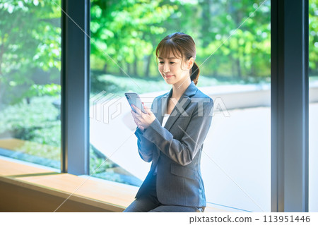 微笑在辦公室操作智能手機的女商人照片合作:LINK FOREST 微笑在辦公室操作智能手機的女商人照片合作:LINK FOREST 113951446