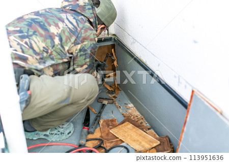 A carpenter repairing a damaged balcony 113951636
